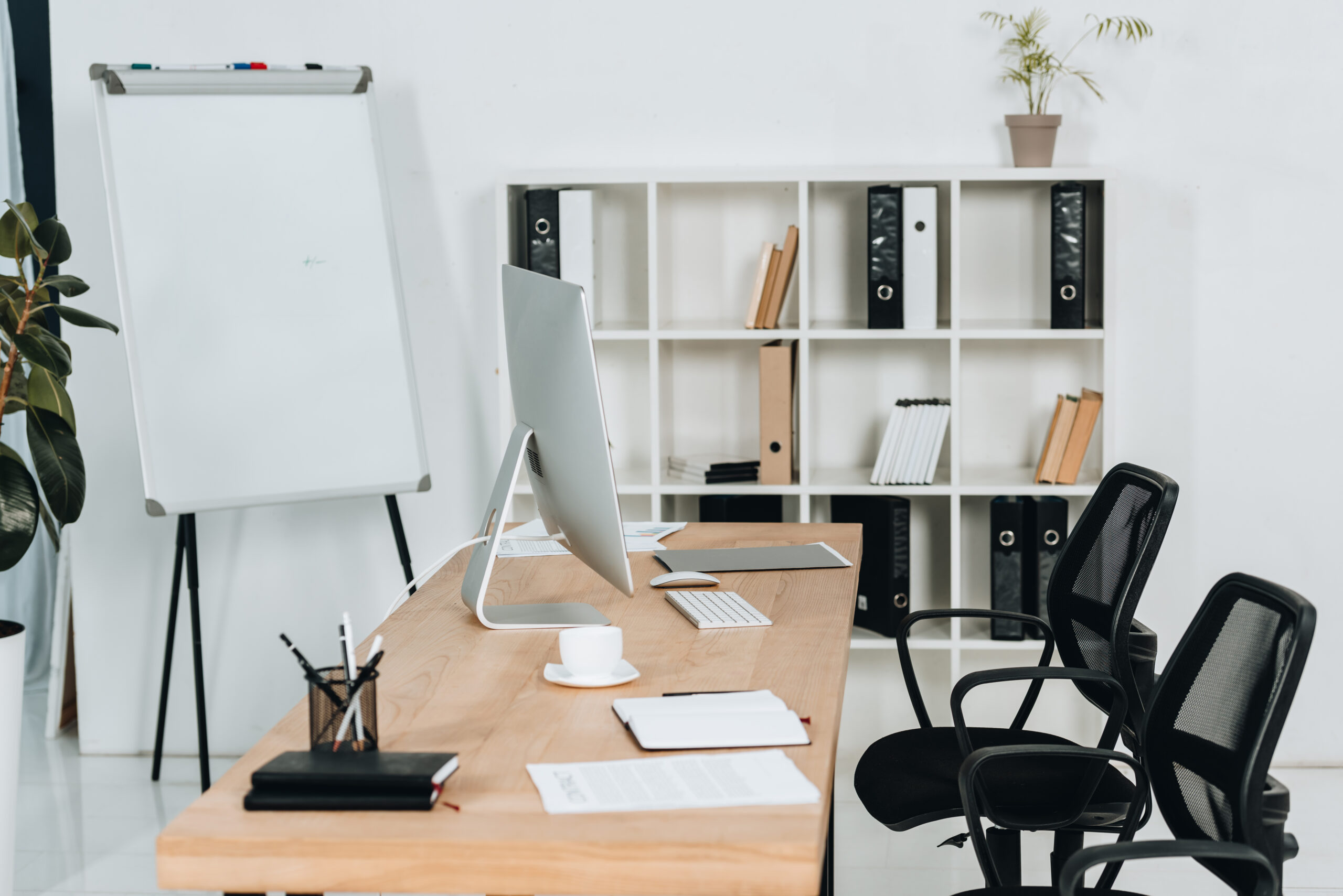 modern office interior with desktop computer and office supplies, chairs and whiteboard
